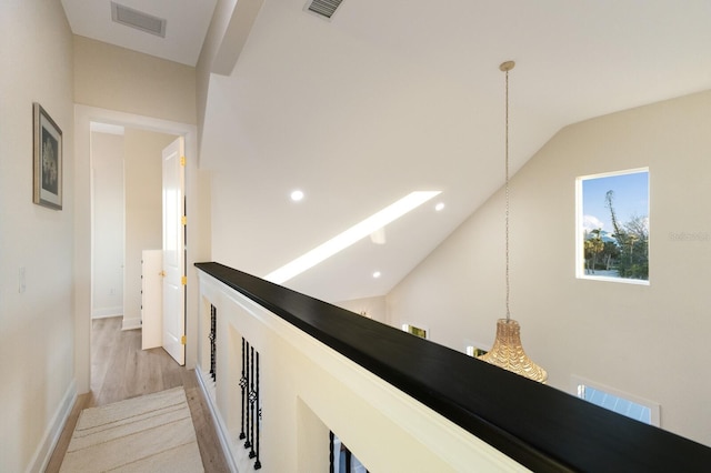 hall with recessed lighting, visible vents, lofted ceiling, and light wood-style floors