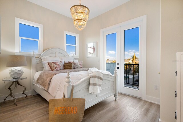 bedroom featuring baseboards, light wood-style floors, and access to outside