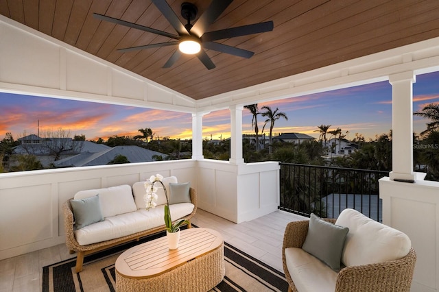 patio terrace at dusk with ceiling fan, a balcony, and an outdoor hangout area