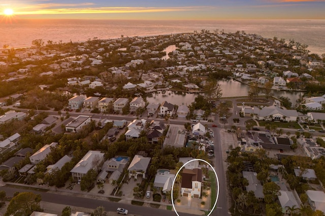 aerial view at dusk featuring a water view and a residential view