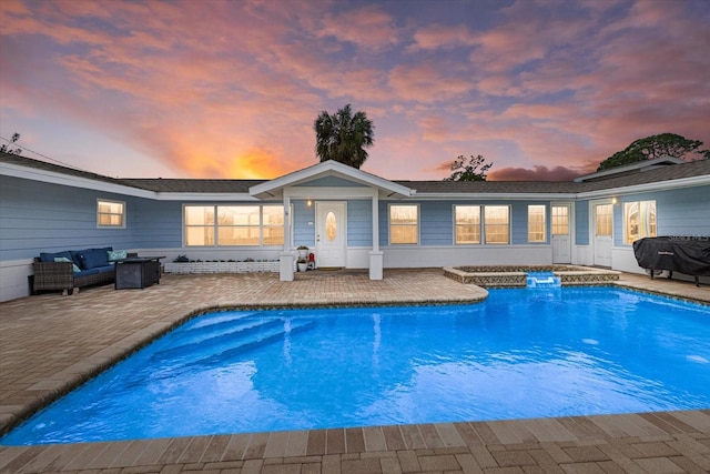 rear view of property featuring a patio and an outdoor pool