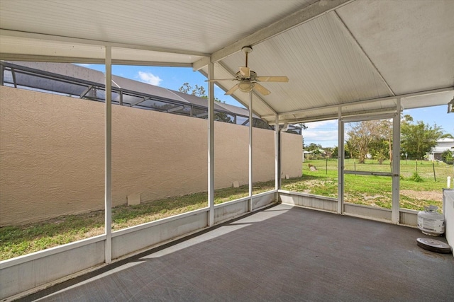 unfurnished sunroom with vaulted ceiling with beams and a ceiling fan