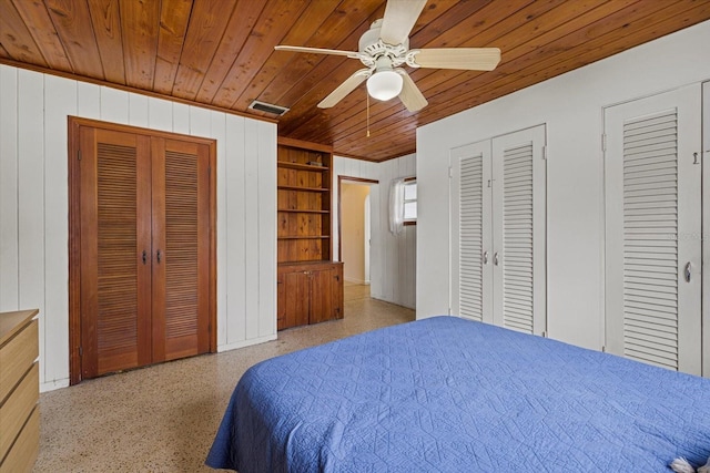 bedroom featuring multiple closets, wooden ceiling, visible vents, and speckled floor