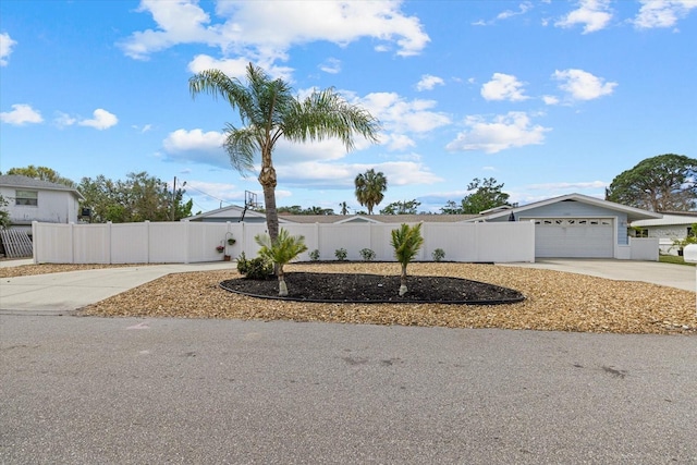 view of front of home featuring a garage, fence private yard, and concrete driveway