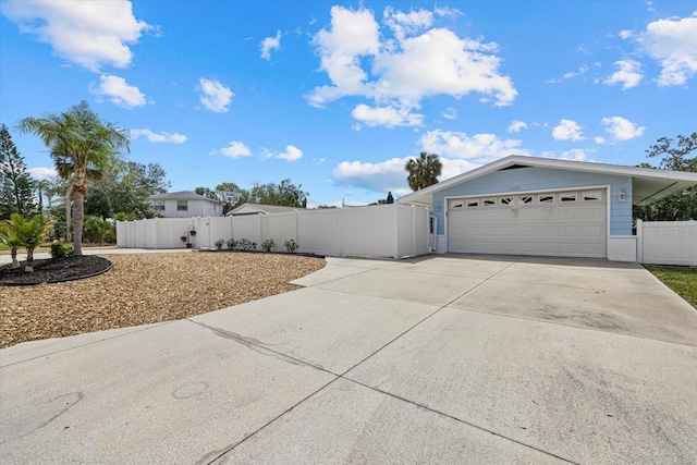 exterior space with a garage, concrete driveway, fence, and a gate