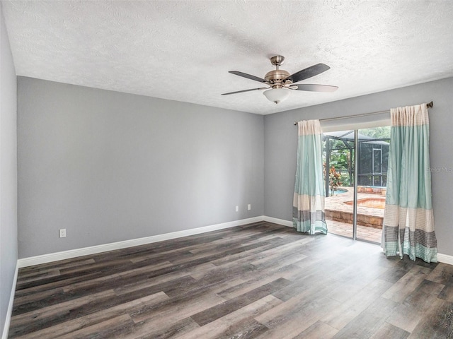 empty room with dark wood finished floors, a ceiling fan, baseboards, and a textured ceiling