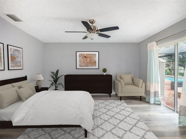 bedroom featuring a ceiling fan, visible vents, access to exterior, light wood-style floors, and a textured ceiling