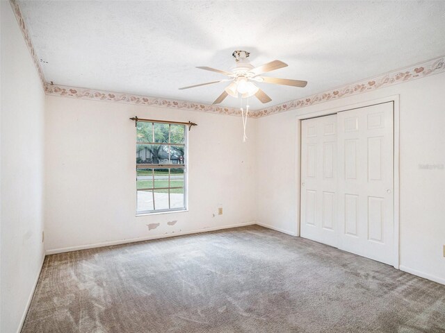 empty room featuring ceiling fan, carpet flooring, baseboards, and a textured ceiling