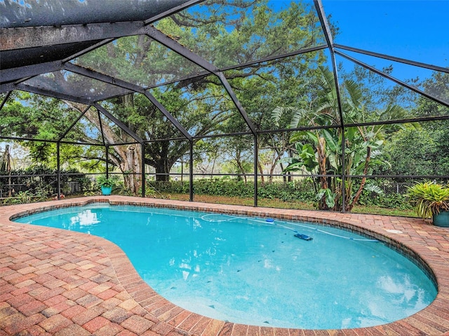 pool featuring glass enclosure and a patio