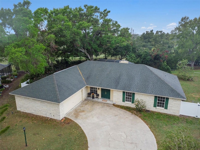 single story home with a front yard, fence, driveway, and roof with shingles