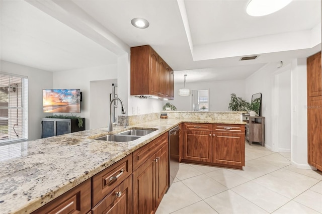 kitchen featuring visible vents, a sink, light stone counters, stainless steel dishwasher, and a peninsula