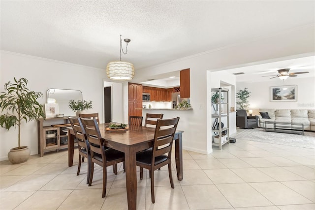 dining space with light tile patterned floors, a textured ceiling, and crown molding