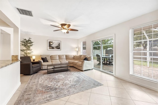 living area featuring light tile patterned flooring, a ceiling fan, and visible vents