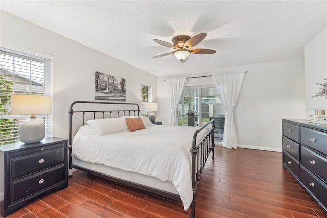 bedroom featuring access to outside, multiple windows, a textured ceiling, and wood tiled floor