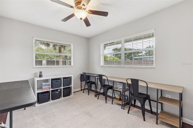 office area featuring a wealth of natural light, ceiling fan, baseboards, and carpet floors