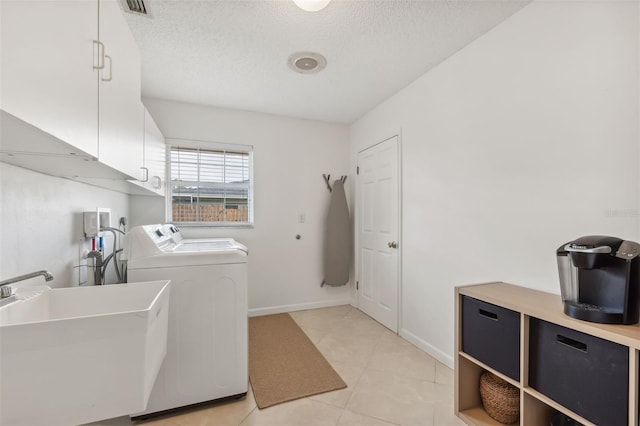 laundry area featuring baseboards, washer and clothes dryer, cabinet space, a textured ceiling, and a sink