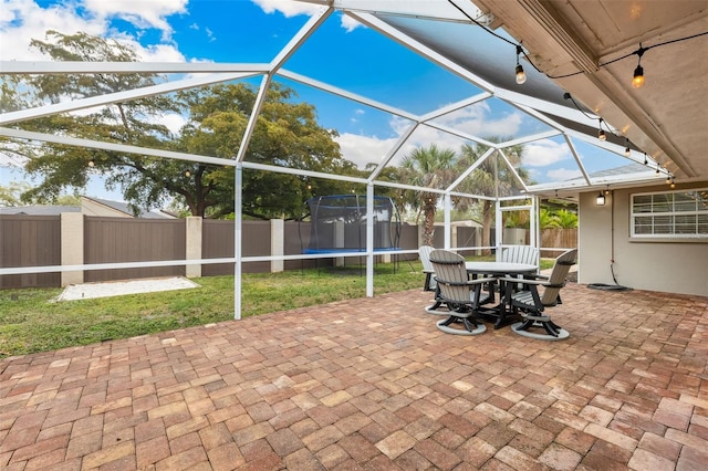 view of patio with an outbuilding, a shed, a fenced backyard, a lanai, and a trampoline