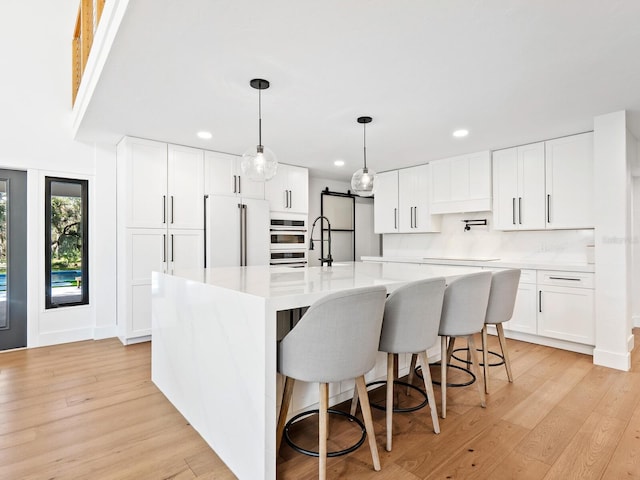 kitchen featuring light wood-type flooring, white appliances, white cabinetry, and light countertops