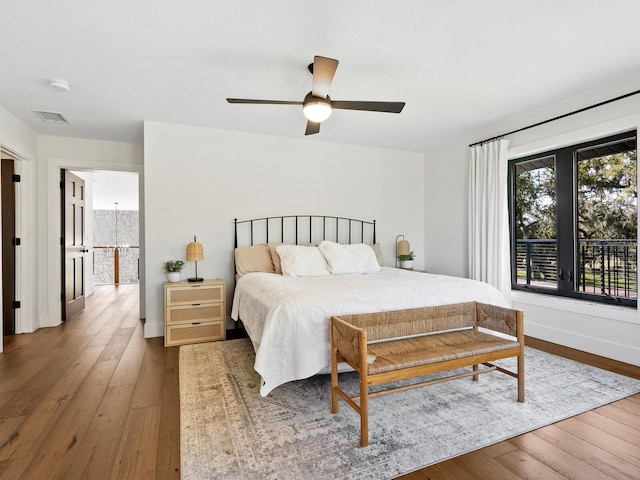 bedroom with visible vents, ceiling fan, baseboards, and hardwood / wood-style flooring