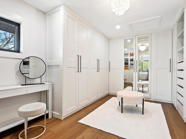 spacious closet with wood finished floors and attic access