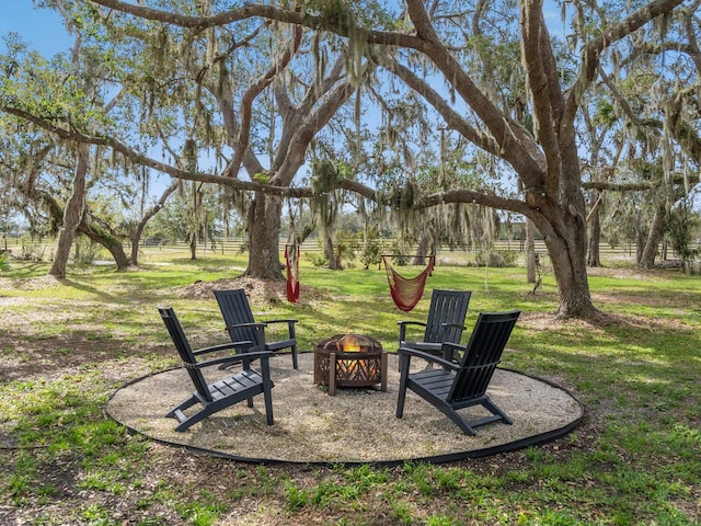 view of yard with fence and a fire pit