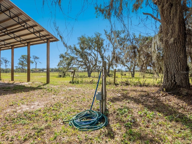 view of yard with a rural view and fence