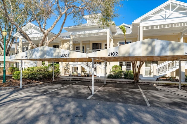 view of property featuring covered parking and stairs