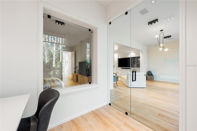 home office with an inviting chandelier, baseboards, visible vents, and wood finished floors