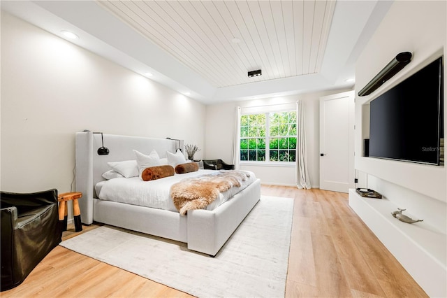 bedroom with recessed lighting, wooden ceiling, a raised ceiling, and light wood-style floors