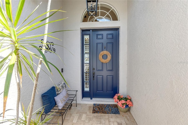 entrance to property featuring stucco siding