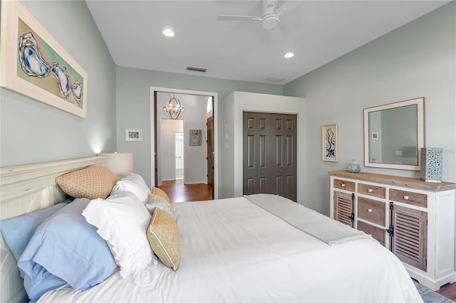 bedroom featuring recessed lighting, ceiling fan with notable chandelier, wood finished floors, visible vents, and a closet