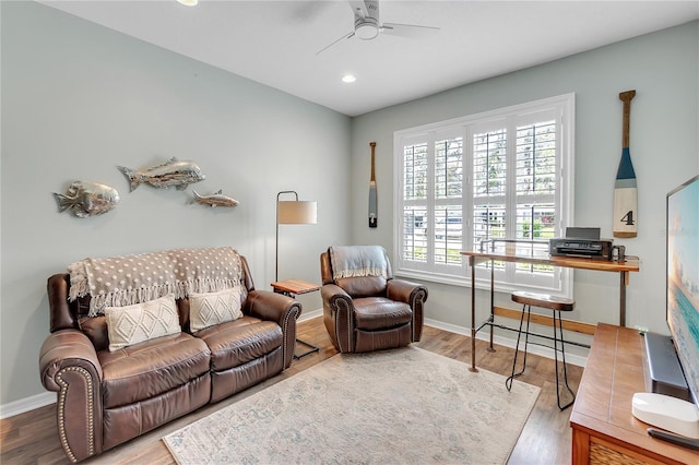 living room featuring ceiling fan, wood finished floors, and baseboards