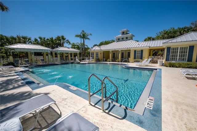 community pool with a patio area and fence