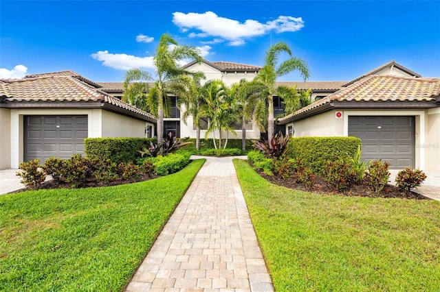 view of front facade with a front yard, a tile roof, an attached garage, and stucco siding