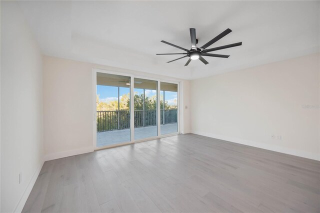 empty room featuring ceiling fan, baseboards, and wood finished floors