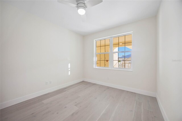 spare room with ceiling fan, baseboards, and wood finished floors