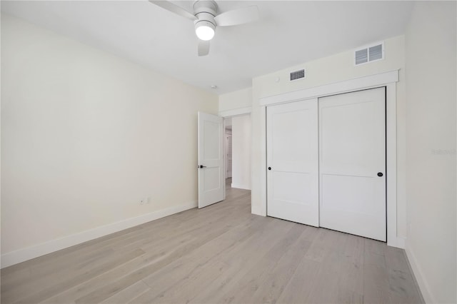 unfurnished bedroom with a closet, visible vents, light wood-style flooring, and baseboards