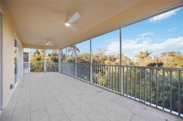 unfurnished sunroom with ceiling fan