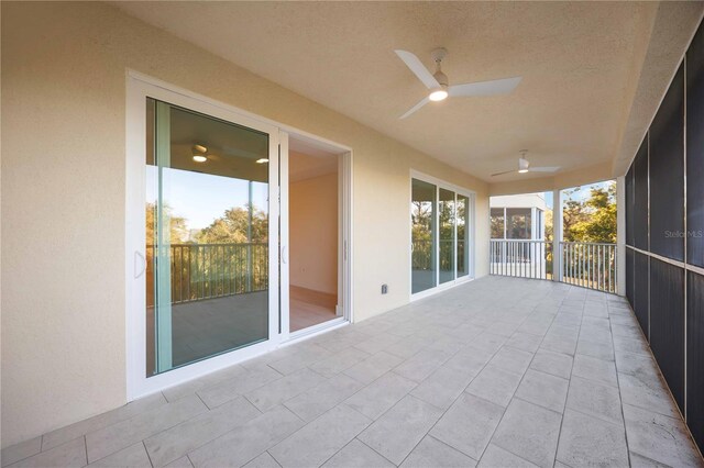 unfurnished sunroom with a wealth of natural light and a ceiling fan