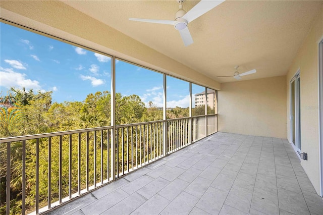 unfurnished sunroom with a ceiling fan