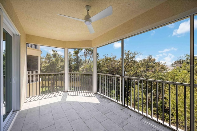 unfurnished sunroom featuring a ceiling fan