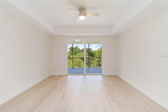 280 Hidden Bay Dr Unit 202, Osprey, FL 34229 - spare room featuring a raised ceiling, baseboards, a ceiling fan, and light wood-style floors