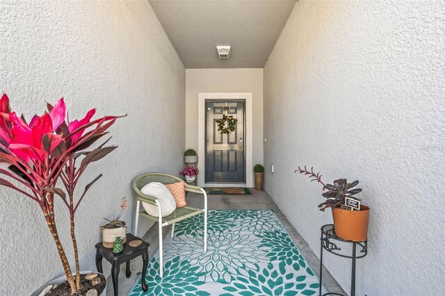 property entrance featuring visible vents and stucco siding