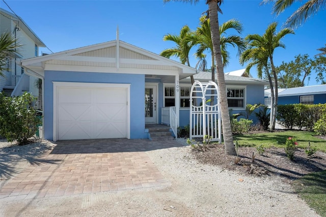 ranch-style house with a garage, decorative driveway, and stucco siding