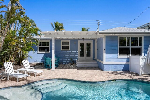 back of property featuring a shingled roof, french doors, a patio area, an outdoor pool, and a pergola