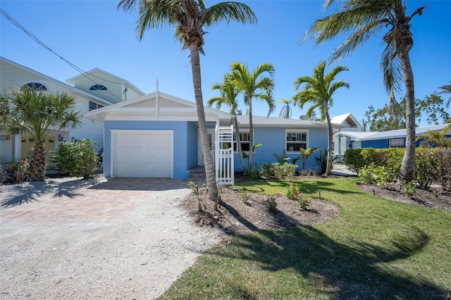 single story home featuring a front yard, decorative driveway, a garage, and stucco siding