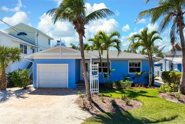 view of front of home with a front lawn, decorative driveway, a garage, and stucco siding