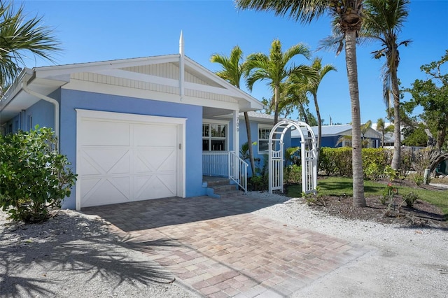 view of front of property with stucco siding, an attached garage, and decorative driveway