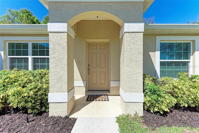 property entrance with stucco siding