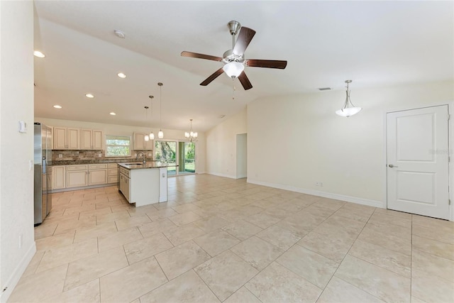 kitchen featuring decorative backsplash, dark countertops, lofted ceiling, open floor plan, and freestanding refrigerator